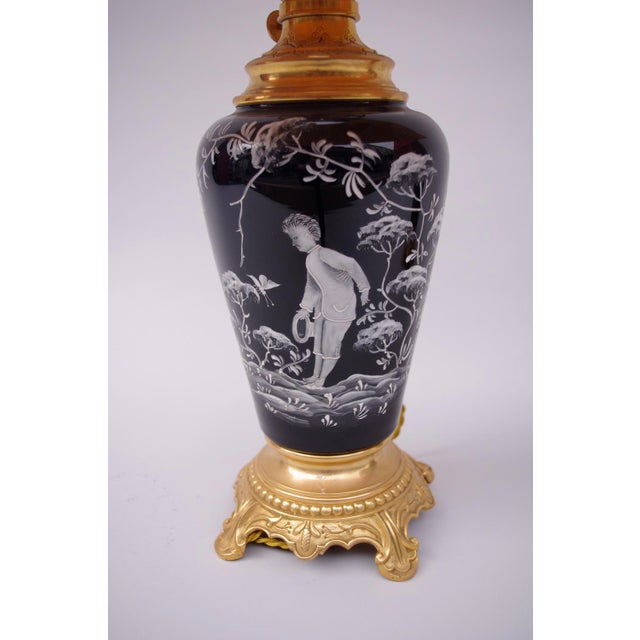 This is a pair of black enamel opaline lamps in a vase shape. The round chiseled and gilt bronze mount on a pearls frieze...