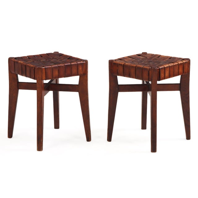 A handsome pair of French oak stools dating to circa 1925, featuring hand-woven leather strap seats above sturdy oak...
