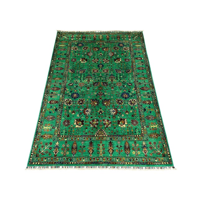 This Sultani rug features a Persian-inspired floral design across a vivid turquoise field. Flowers, leaves, and winding...