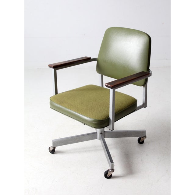 This mid-20th century vintage office chair from United Chair Company features an olive green tweed seat and vinyl back,...