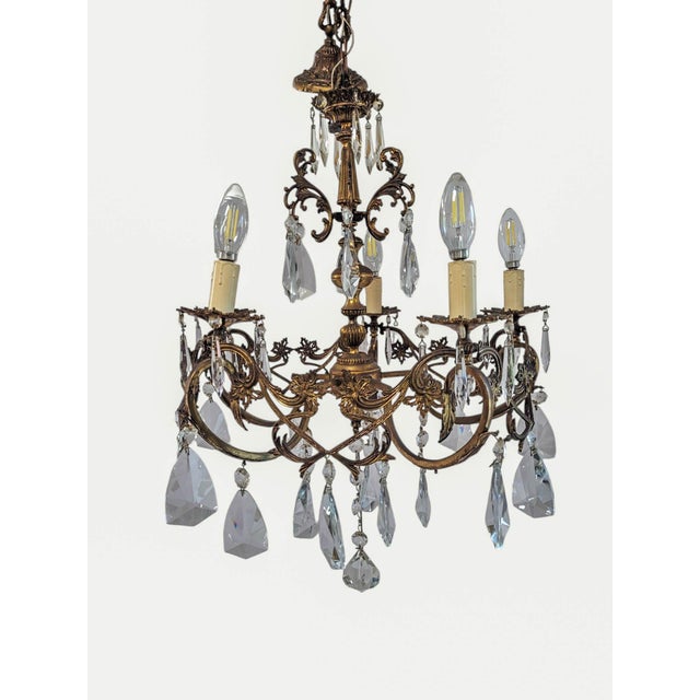 A striking French Rococo Revival chandelier combining sculptural cast bronze metalwork with dramatic hand-cut crystal...
