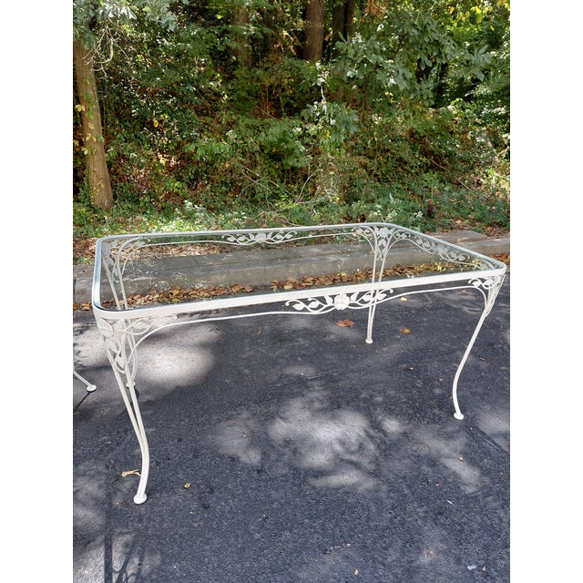A vintage five-piece garden dining set featuring a rectangular glass-top table and four coordinating side chairs. The...