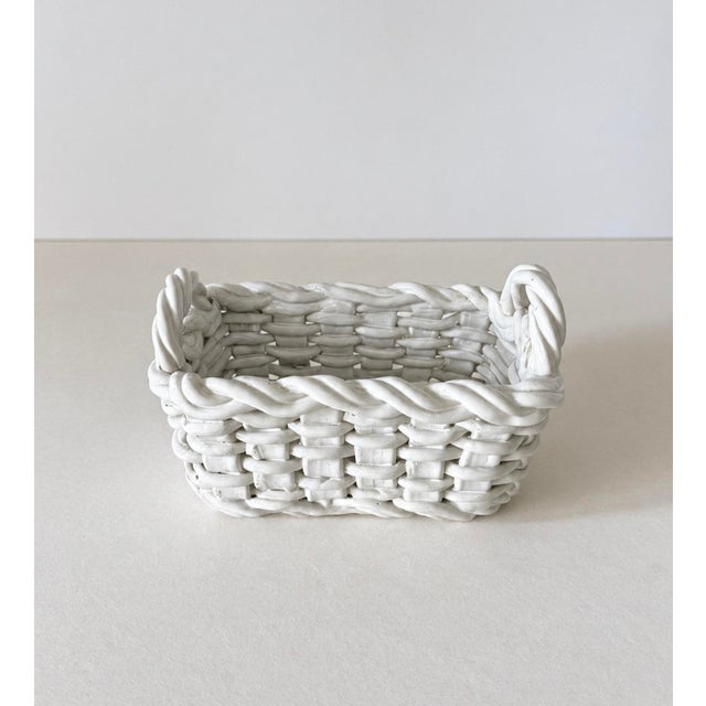 Rectangular shaped woven ceramic basket with handles in a glossy white glaze. Incised "MADE IN ITALY" on base....