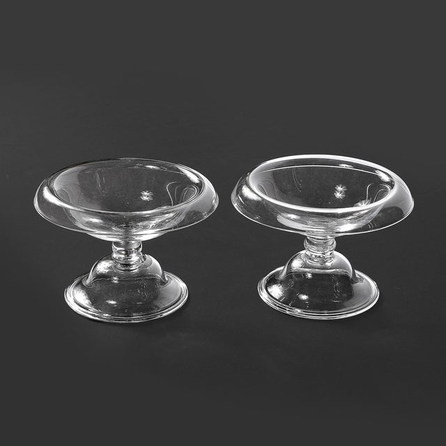 This pair of Mid-Century Modernist footed tazas, signed by Steuben and created circa 1960, exemplifies the artistry and...