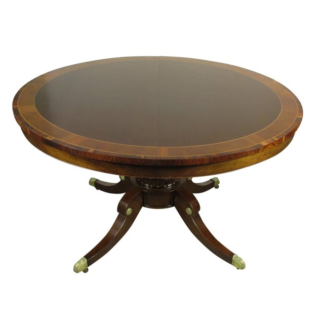 A Regency style inlaid mahogany dining table by Old Colony with a single pedestal base and three extension leaves....