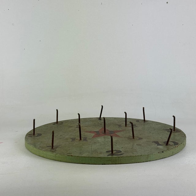 A vintage round ring toss game board in avocado green and red star in the center. A fun decorative addition to almost any...