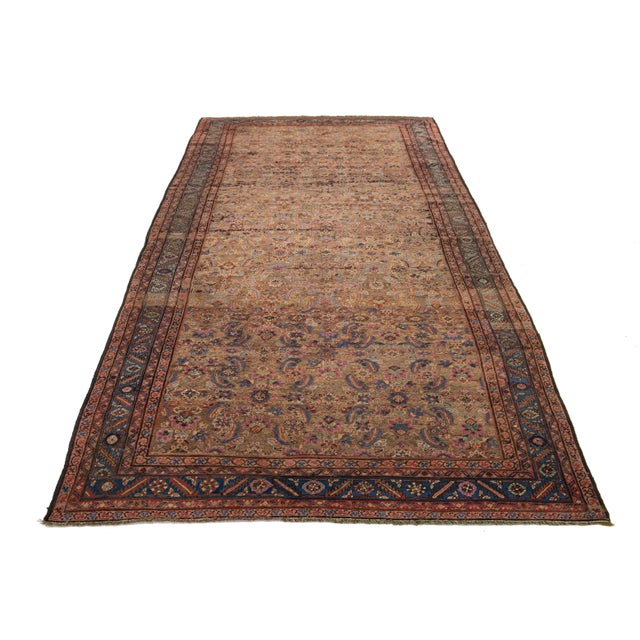 This Bakshaeish Persian hand-knotted rug showcases a striking brown field enhanced by multicolored accents, intricately...