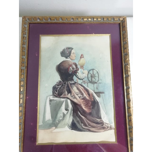 Watercolor on paper of excellent execution depicting a woman spinning with an antique spinning wheel. Genre subject by an...