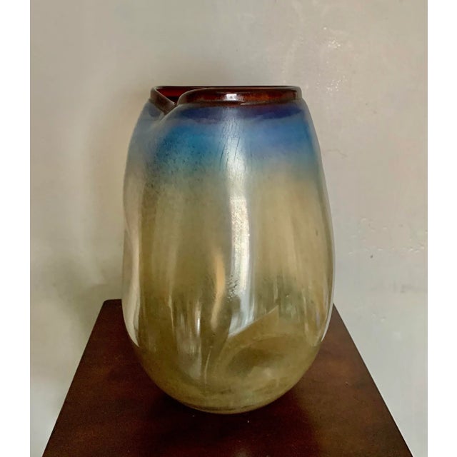 Stunning 13” high art glass vase in hues of gold, blue and amber Bent sides and cracked finish Great for a modern,...