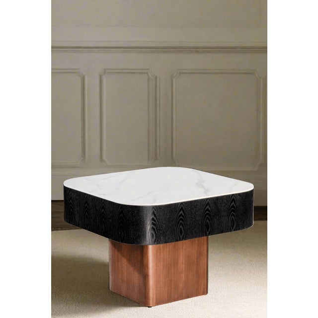 Crafted with sleek ceramic top with rounded edges, black wood side and bronze metal base, this coffee table combines...
