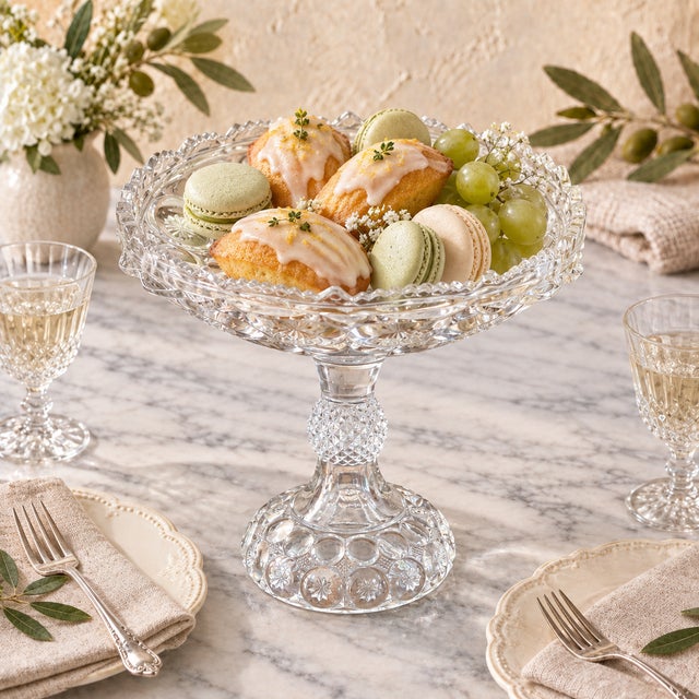 A substantial vintage clear pressed-glass pedestal compote featuring the traditional Daisy & Button pattern. The shallow...