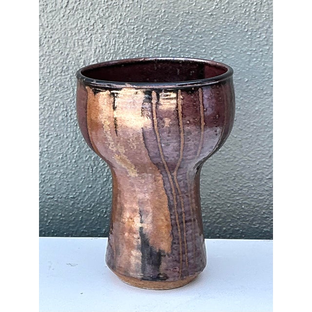 This striking vintage studio pottery vase is a compelling example of 1970s hand-thrown ceramic art. Featuring a bold,...
