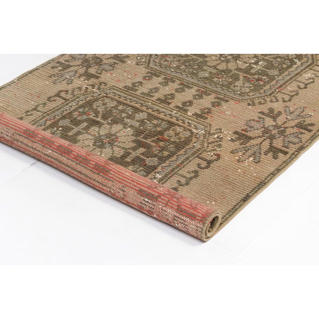 This is a vintage Turkish Oushak rug from the Mid 20th Century. The piece was hand-knotted.
