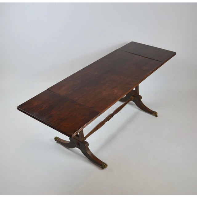 Elegant British Regency-style drop-leaf coffee table, dating from the early 20th century, circa 1920s. The rectangular top...