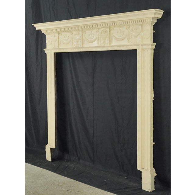 English Regency style fireplace mantel with a thick layer of tan paint. It features beaded, dentil, and egg & dart molding...
