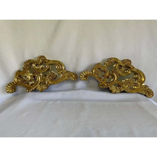 A beautiful and unique pair of Mirrored Wall Swags / Sconces with a gilded finish. Circa Mid 20th Century. These stunning...