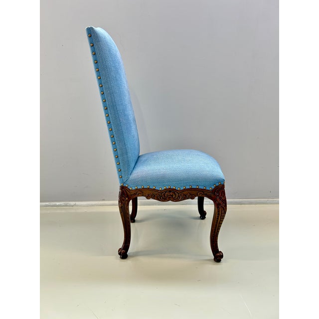 Dining chair in carved wood with floral decoration. Upholstered in blue fabric. Both the upholstery and the wood are in...
