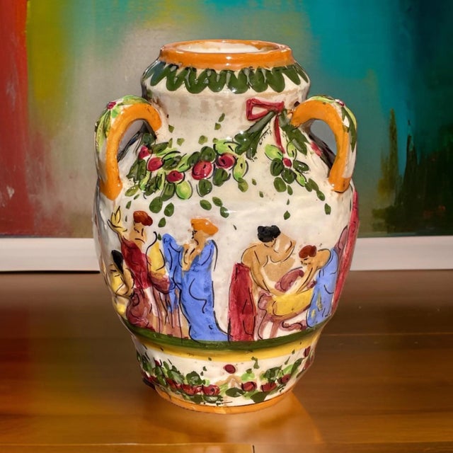 A stunning vintage Italian majolica decorative ceramic vase with three handles decorated with a colorful hand-painted,...