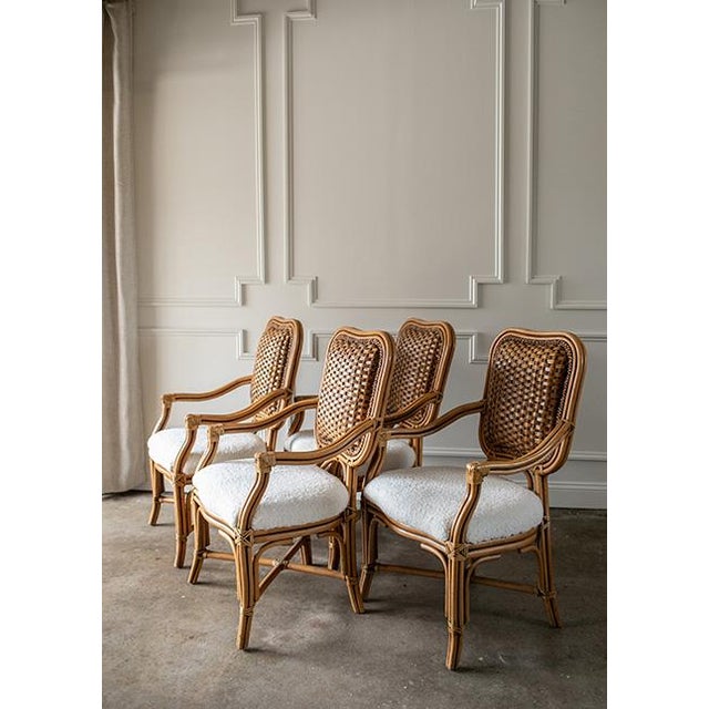 A gorgeous, rare set of four vintage Padma’s Plantation armchairs featuring intricate woven rattan backs and newly updated...