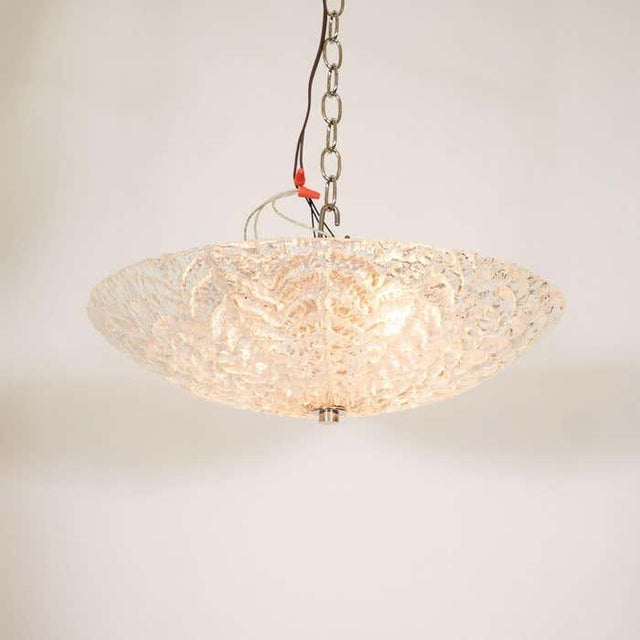 Glass flush mount fixture with leaf texture motif.