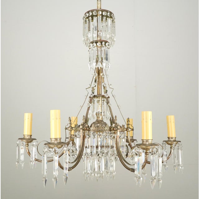 Rococo Revival waterfall crystal chandelier with six sweeping arms. Five tiers of icicle prisms at the center of the...