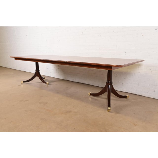 An exceptional Georgian or Regency style double pedestal extension dining table In the manner of Baker Furniture England,...