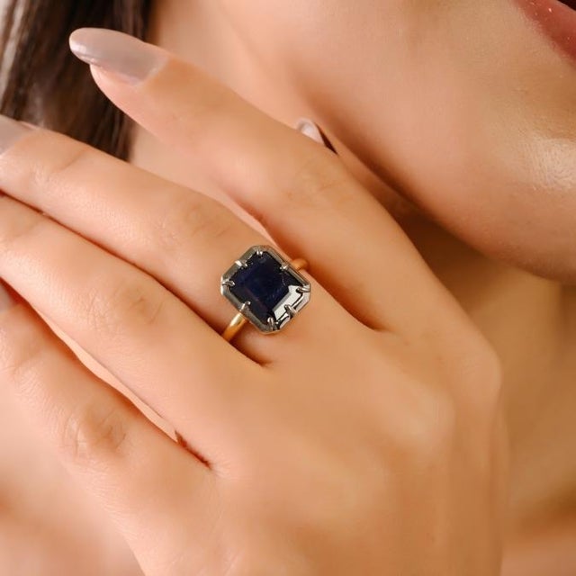 This exquisite 18K yellow gold statement ring showcases a stunning octagon-cut deep blue sapphire weighing approximately...