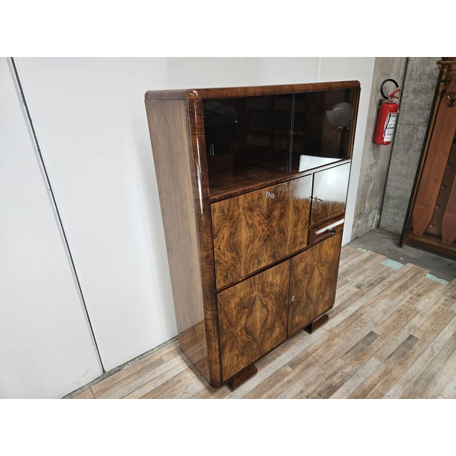 An elegant Austrian display cabinet from the 1930s, featuring a refined Central European Art Deco style and a spectacular,...