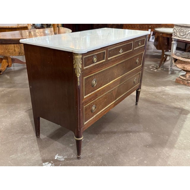 Late 19th century French Louis XVI style oak and brass commode with with marble. A French Louis XVI commode with a marble...