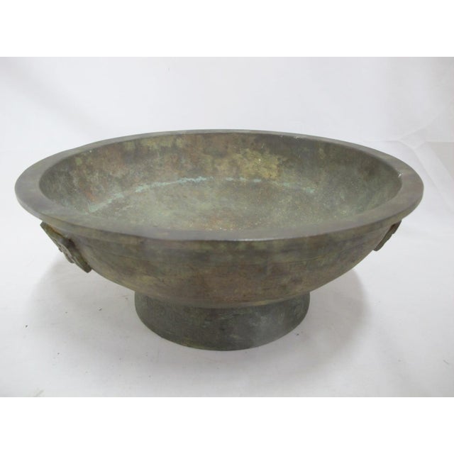 Large, heavy antique Chinese bronze vessel. Footed bowl or censer, featuring 3 high relief mask decorations and engraved...