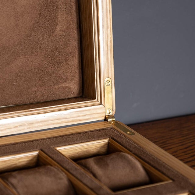 Featuring a sleek contemporary design, this modern 21st Century watch case showcases an oak carcass with brass hinges and...