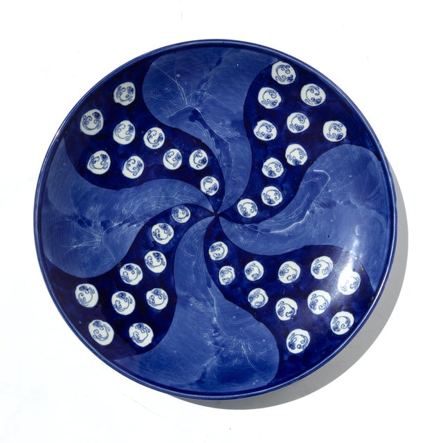 Large blue and white Imari charger on later wood stand. The interior displays a radiating pinwheel pattern in cobalt blue...