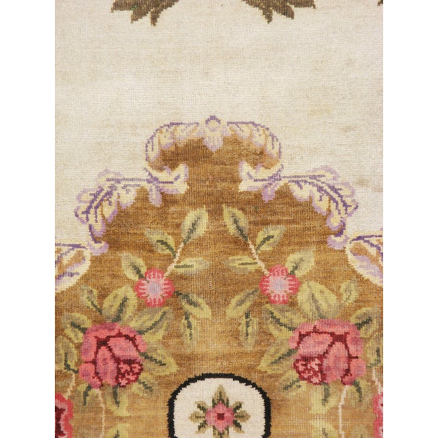 A vintage European continental carpet from the mid-20th century. A large golden brown medallion of roses populates the...