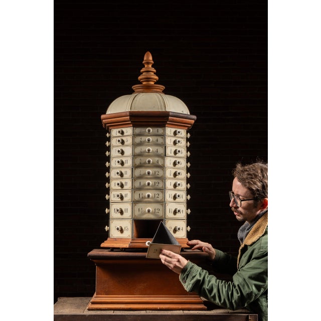 Large wooden rotating parts cabinet constructed in a hexagonal form, surmounted by a turned finial and paneled domed top....