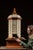 Large wooden rotating parts cabinet constructed in a hexagonal form, surmounted by a turned finial and paneled domed top....