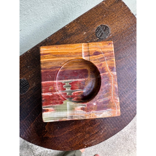 A stunning pair of solid onyx ashtrays/catchall (sold a pair) in square form with a polished circular well, each hewn from...