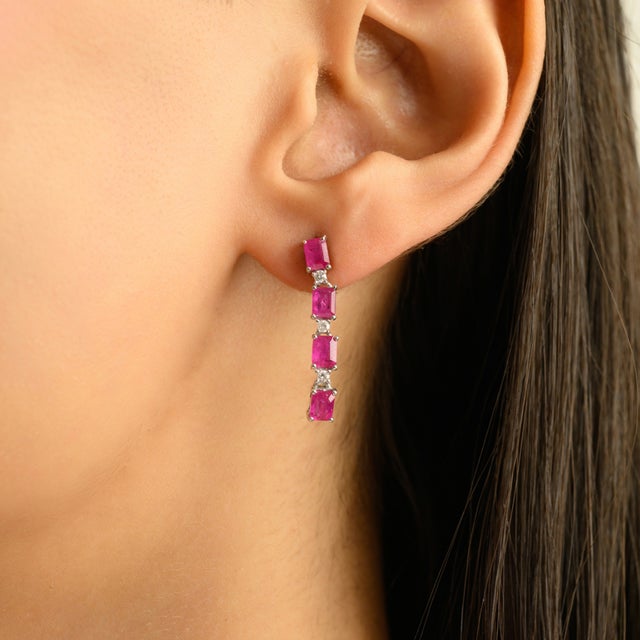 Elegant sterling silver line earrings featuring vibrant pink rubies in a sleek vertical bar design. The earrings showcase...