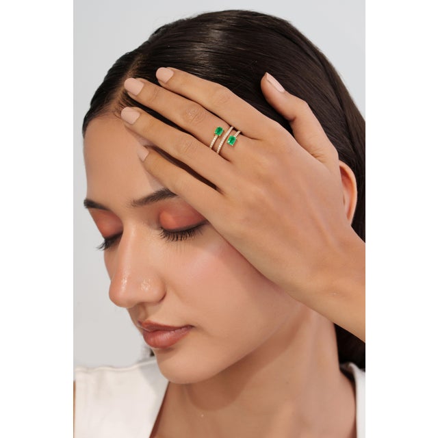 This handcrafted spiral wrap ring showcases 0.8 carats of natural emeralds set in 14K yellow gold. The two emeralds, each...