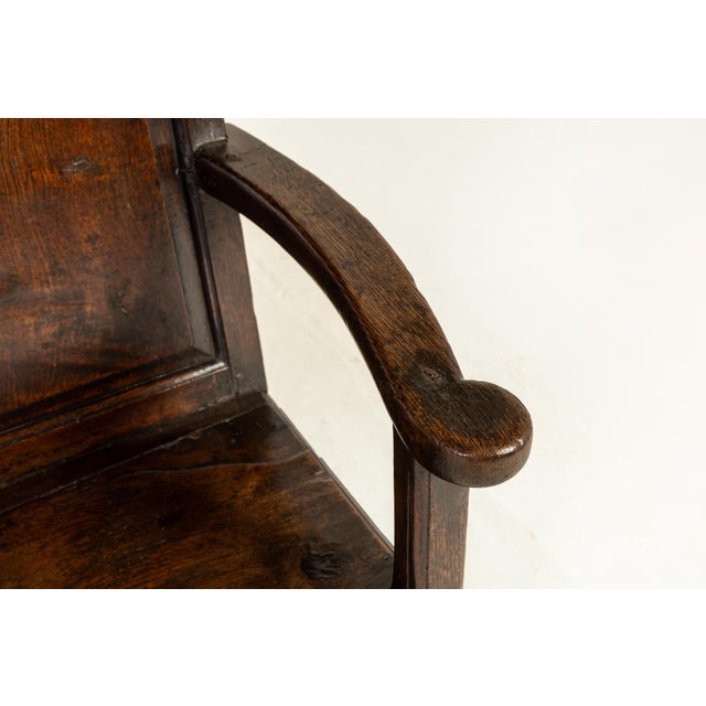 18th Century English oak settle with a high back. Unusual format of five fielded panels at the back mirrored on the font...
