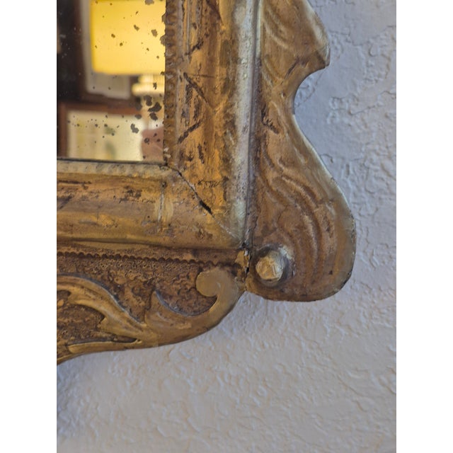 Impressive 18th century English wall mirror handcrafted in hardwood with a broken sediment and floral carvings throughout,...