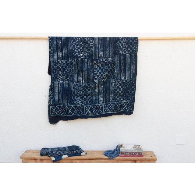 A masterwork of Malian textile heritage featuring deep indigo saturation and symbolic geometric motifs. Originating from...