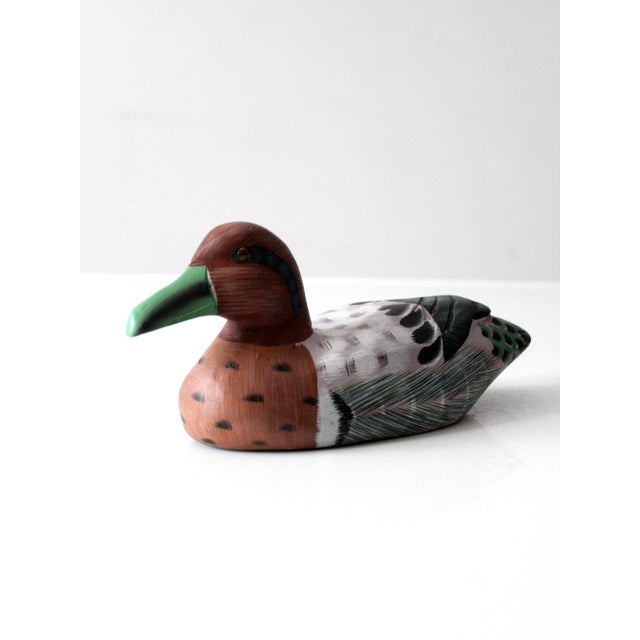 A vintage hand-carved and hand-painted wood duck depicting a Green-winged Teal drake. The finely shaped form features...
