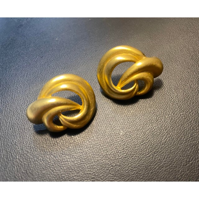 A harmonious pairing defined by their shared matte gold finish—a soft, brushed texture popularized during Hollywood’s...