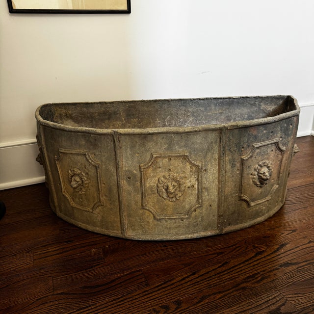 19th century French lead planter is centered on repeating panels with lion heads within a fielded surround.