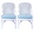Charming pair of vintage white wicker rattan armchairs featuring a classic coastal silhouette with gently curved arms and...