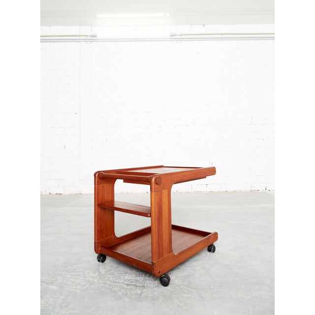 Elegant, C-shaped tea trolley/bar cart made of high-quality teak in a Scandinavian mid-century modern style. This piece of...