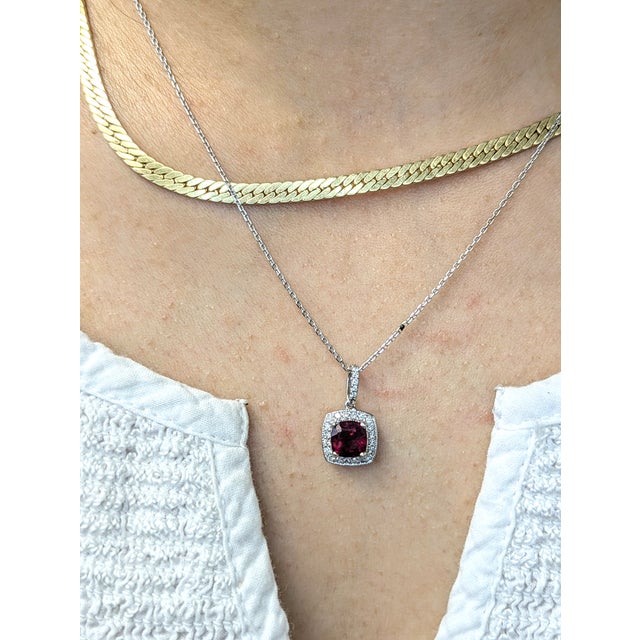 This beautiful pendant features a 1.24 carat cushion cut ruby gemstone with a halo of natural earth mined diamonds and a...