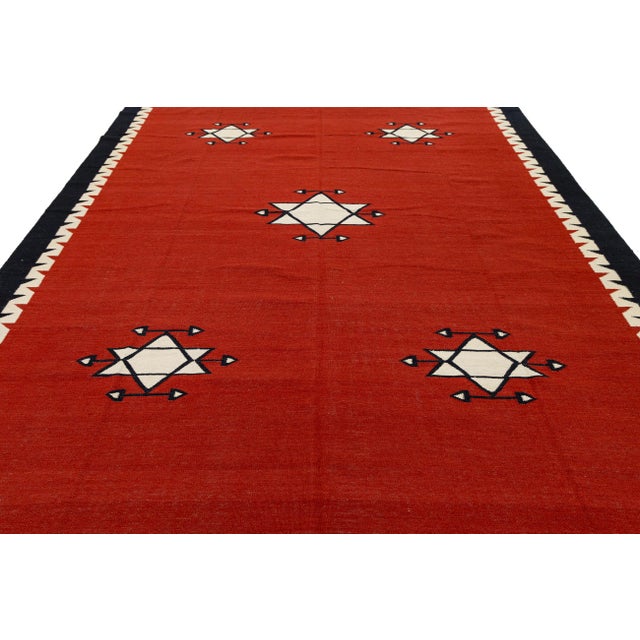 This striking handmade wool rug features a bold, contemporary interpretation of traditional Navajo weaving patterns....