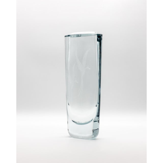 A heavy hand-blown Strömbergshyttan vase in thick clear glass with a soft blue-silver tint and finely engraved bird motif....