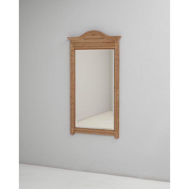 A 1910s Belgian oak mirror defined by its clean architectural lines and understated decorative presence. The frame is...